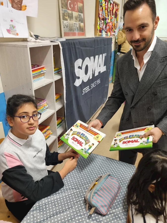 SOMAL destekli Sıfır Atık Eğitim Seti’ni teslim alan öğrenci, çevre bilinci eğitimiyle buluşuyor; firma temsilcisi öğrencilere set dağıtımı yapıyor.