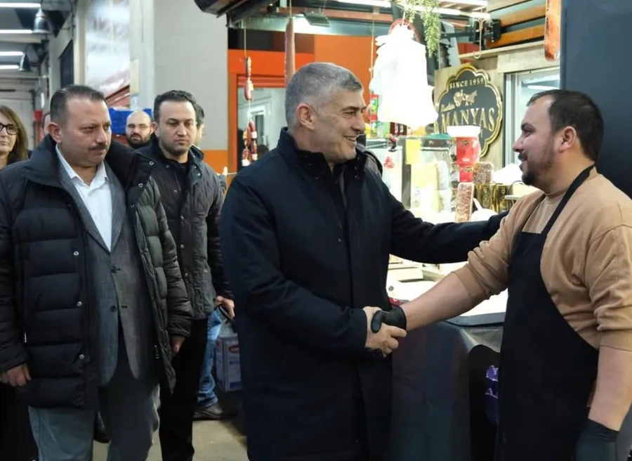 Feti Ahmet Balin Bahçekent’te esnaf ziyareti sırasında işyeri sahibine selam verip tokalaşırken, Ramazan iftar programı öncesi saha buluşması